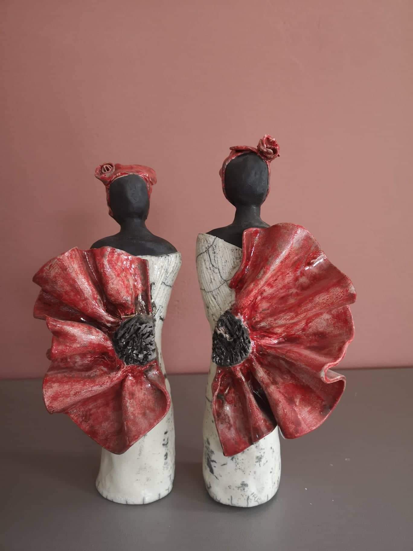 Sculptures en poterie de deux femmes noires.